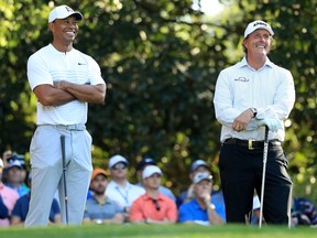 In this April 3 file photo, Tiger Woods and Phil Mickelson talk on the 11th hole during a practice round at the Masters.