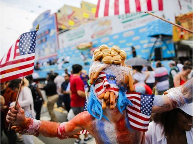People attend the annual Nathan's Hot Dog Eating Contest on July 4, 2018 in the Coney Island neighborhood of the Brooklyn borough of New York City. Joey Chestnut won the contest, eating a Coney Island record 74 hot dogs in 10 minutes.