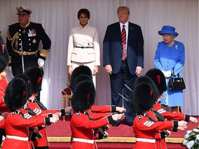 WINDSOR, ENGLAND - JULY 13:  Britain's Queen Elizabeth II (2R) stands with US President Donald Trump (R) and US First Lady Melania Trump (2L) on the dias in the Quadrangle as Coldstream Guards perform a march past during a ceremonial welcome at Windsor Castle on July 13, 2018 .