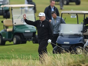 TURNBERRY, SCOTLAND - JULY 15: U.S. President Donald Trump waves whilst playing a round of golf at Trump Turnberry Luxury Collection Resort during the U.S. President's first official visit to the United Kingdom on July 15, 2018 in Turnberry, Scotland. The President of the United States and First Lady, Melania Trump on their first official visit to the UK after yesterday's meetings with the Prime Minister and the Queen is in Scotland for private weekend stay at his Turnberry. (Photo by Leon Neal/Getty Images)