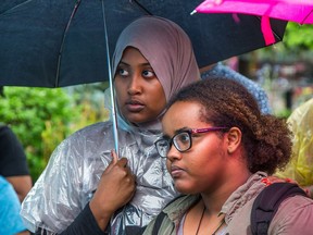 Fadumo Aden and Hodsn Omar listen to speeches during a community gathering in Somerset Square Park by the Justice for Abdirahman Coalition on the second anniversary of Abdirahman Abdi's death during an altercation with police.