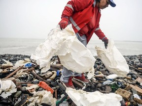 Groups of volunteers clean up plastic waste on a beach in Lima, during the World Environment Day on June 5, 2018.