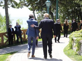 Canadian Prime Minister Justin Trudeau (L) walks with US President Donald Trump during the official G7 Summit welcoming ceremony, June 8, 2018 in La Malbaie, Canada.