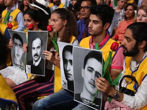 People hold pictures of relatives killed by the Mohllas regime, during "Free Iran 2018 - the Alternative" event on June 30, 2018 in Villepinte, north of Paris during the Iranian resistance national council (CNRI) annual meeting.