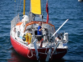 British skipper Susie Goodall looks over from the helm of her boat "DHL Starlight" as she leaves Les Sables d'Olonne Harbour on July 1, 2018, at the start of the solo around-the-world "Golden Globe Race" ocean race in which sailors compete without high technology aides such as GPS or computers.