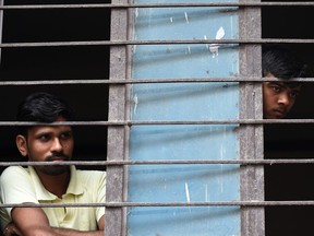 Neighbours look out from a window near the building where 11 family members were found dead inside their home in the neighbourhood of Burari in New Delhi on July 1, 2018. Police have cordoned off the home in Burari in the north of the capital where the bodies of seven women and four men were discovered July 1. "10 of the 11 family members were found hanging when we reached the house. The last, a 75-year-old female, was dead on the floor," a Delhi police official told AFP.