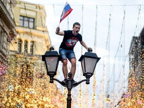 TOPSHOT - A Russia's fan celebrates in central Moscow after Russia won the Russia 2018 World Cup round of 16 football match against Spain on July 1, 2018.