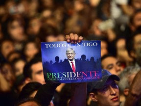 TOPSHOT - Supporters of the presidential candidate for the "Juntos haremos historia" coalition, Andres Manuel Lopez Obrador, celebrate at the Zocalo square in Mexico City, after getting the preliminary results of the general elections on July 1, 2018.  Anti-establishment leftist Andres Manuel Lopez Obrador won Mexico's presidential election Sunday by a large margin, according to exit polls, in a landmark break with the parties that have governed for nearly a century.