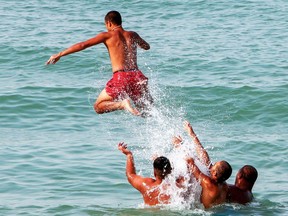 Swimmers throw one another into the water.