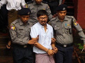 Detained Myanmar journalist Wa Lone (C) is escorted by police from a courthouse following his ongoing pre-trial hearing in Yangon on July 9, 2018. Two Reuters reporters accused of breaking Myanmar's draconian secrecy law during their reporting of the Rohingya crisis must face trial, a judge ruled on July 9, on a charge that carries up to 14 years in jail.