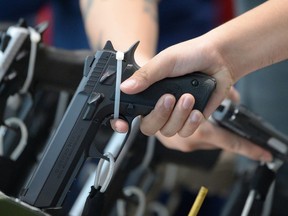 A potential buyer examines a handgun for sale.