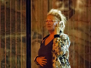 A woman who lives on Danforth St. tries to call her boyfriend at the scene of a shooting in Toronto, Ontario, Canada on July 23, 2018.  A gunman opened fire in central Toronto on Sunday night, injuring 13 people including a child. Two dead including gunman, police reported.