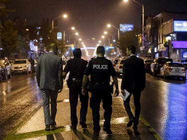 Toronto Police officers work on Danforth St., at the scene of a shooting in Toronto, Ontario, Canada on July 23, 2018.  A gunman opened fire in central Toronto on Sunday night, injuring 13 people including a child. Two dead including gunman, police reported.