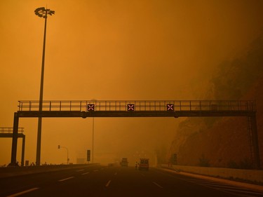 This photo taken on July 23, 2018 shows a road block as a wildfire burns in Kineta, near Athens.