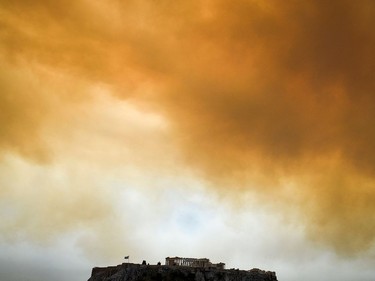 TOPSHOT - A picture taken on July 23, 2018 shows the Parthenon temple on the Acropolis hill in Athens as smoke billows in background during a wildfire in Kineta, near Athens.