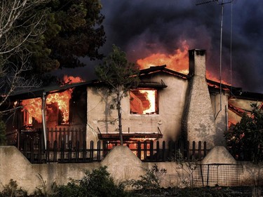 A house burns during a wildfire in Kineta, near Athens, on July 23, 2018. More than 300 firefighters, five aircraft and two helicopters have been mobilised to tackle the "extremely difficult" situation due to strong gusts of wind, Athens fire chief Achille Tzouvaras said.