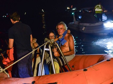 Rescuers and volunteers help local people evacuate the village of Mati during a wildfire near Athens, on July 23, 2018. At least five people have died and more than 20 have been injured as wild fires tore through woodland and villages around Athens on Monday, while blazes caused widespread damage in Sweden and other northern European nations. More than 300 firefighters, five aircraft and two helicopters have been mobilised to tackle the "extremely difficult" situation due to strong gusts of wind, Athens fire chief Achille Tzouvaras said.