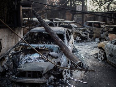 A photo taken on July 24, 2018 shows cars burnt following a wildfire at the village of Mati, near Athens, on July 24, 2018.  Fifty people have died and 170 have been injured in wildfires ravaging woodland and villages in the Athens region, as Greek authorities rush to evacuate residents and tourists stranded on beaches along the coast on July 24, 2018. The death toll soared with a Red Cross official reporting the discovery of 26 bodies in the courtyard of a villa at the seaside resort of Mati.