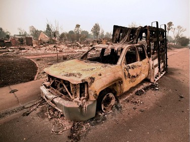 A destroyed truck is seen among the ruins of a burned neighborhood after the Carr fire passed through the area of Lake Keswick Estates near Redding, California on July 28, 2018.  The US federal government approved aid Saturday for California as thousands of firefighters battled to contain a series of deadly raging wildfires that have killed six people and destroyed hundreds of buildings.