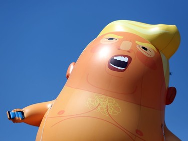 A six-meter high cartoon baby blimp of U.S. President Donald Trump is flown as a protest against his visit, in Parliament Square in London, England, Friday, July 13, 2018.