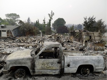 A burned out vehicle sits in front of a wildfire-ravaged home Saturday, July 28, 2018, in Redding, Calif.