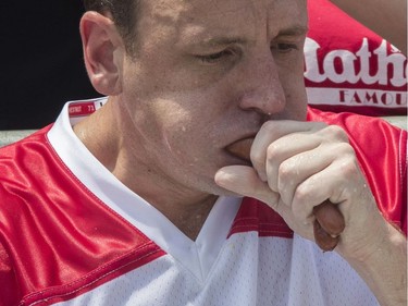 Reigning champion Joey Chestnut eats two hot dogs at a time during the men's competition of the Nathan's Famous Fourth of July hot dog eating contest, Wednesday, July 4, 2018, in New York's Coney Island. The defending champion  broke his own world record by eating 74 hot dogs in 10 minutes.
