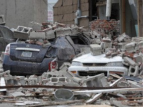 Vehicles are covered in rubble from a tornado damaged building, Friday, July 20, 2018, in Marshalltown, Iowa. Several buildings were damaged Thursday evening by a tornado in the main business district in town including the historic courthouse.