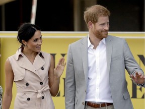 Britain's Prince Harry, right, and his wife Meghan the Duchess of Sussex wave at onlookers as they arrive for their visit to the launch of the Nelson Mandela Centenary Exhibition, marking the 100th anniversary of anti-apartheid leader's birth, at the Queen Elizabeth Hall in London, Tuesday, July 17, 2018.