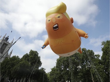 A six-meter high cartoon baby blimp of U.S. President Donald Trump is flown as a protest against his visit, in Parliament Square in London, England, Friday, July 13, 2018. Trump is making his first trip to Britain as president after a tense summit with NATO leaders in Brussels and on the heels of ruptures in British Prime Minister Theresa May's government because of the crisis over Britain's exit from the European Union.