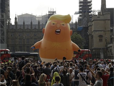 A six-meter high cartoon baby blimp of U.S. President Donald Trump is flown as a protest against his visit, in Parliament Square in London, England, Friday, July 13, 2018. Trump is making his first trip to Britain as president after a tense summit with NATO leaders in Brussels and on the heels of ruptures in British Prime Minister Theresa May's government because of the crisis over Britain's exit from the European Union.