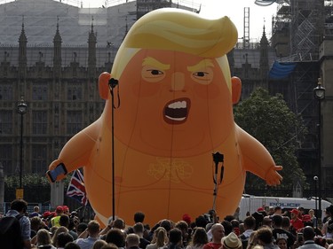 A six-meter high cartoon baby blimp of U.S. President Donald Trump is flown as a protest against his visit, in Parliament Square in London, England, Friday, July 13, 2018. Trump is making his first trip to Britain as president after a tense summit with NATO leaders in Brussels and on the heels of ruptures in British Prime Minister Theresa May's government because of the crisis over Britain's exit from the European Union.