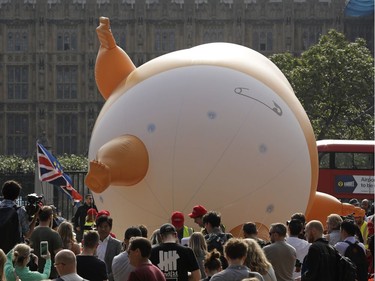 A six-meter high cartoon baby blimp of U.S. President Donald Trump is inflated as a protest against his visit, in Parliament Square in London, England, Friday, July 13, 2018. Trump is making his first trip to Britain as president after a tense summit with NATO leaders in Brussels and on the heels of ruptures in British Prime Minister Theresa May's government because of the crisis over Britain's exit from the European Union.