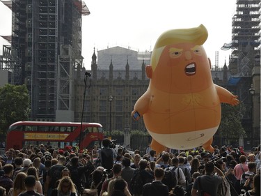 A six-meter high cartoon baby blimp of U.S. President Donald Trump is flown as a protest against his visit, in Parliament Square backdropped by the scaffolded Houses of Parliament and Big Ben in London, England, Friday, July 13, 2018. Trump is making his first trip to Britain as president after a tense summit with NATO leaders in Brussels and on the heels of ruptures in British Prime Minister Theresa May's government because of the crisis over Britain's exit from the European Union.