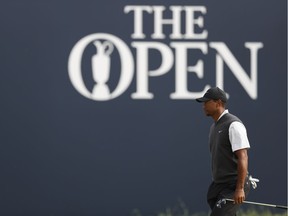 Tiger Wood walks across the 18th green at Carnoustie as he completes the third round of the Open Championship on Saturday. He's four strokes off the lead going into the final round Sunday.