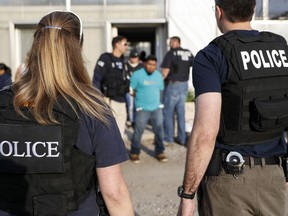 FILE - In this June 5, 2018 file picture, government agents detain suspects during an immigration raid in Castalia, Ohio. Regular raids are a key part of President Donald Trump's administration's crackdown on immigrants living in the U.S. illegally.