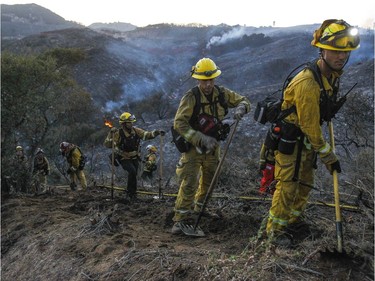 A hand crew of firefighters from various San Diego County fire departments scratch out a fire line after a brushfire burned in De Luz, Calif., on Saturday, July 28, 2018. (Hayne Palmour IV/The San Diego Union-Tribune via AP) ORG XMIT: CADIU801