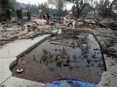 Debris and charred items litter a wildfire-ravaged home Saturday, July 28, 2018, in Redding, Calif.