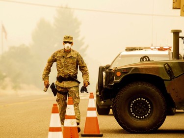 Army National Guard Specialist Gonzalez mans a checkpoint as the Carr Fire burns in Redding, Calif., on Saturday, July 28, 2018. Thousands of residents remain evacuated as the blaze, which has killed multiple people, threatens homes in Redding and surrounding communities.
