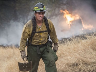 Firefighter Vincent Plant of San Diego, Calif., with the United States Fish and Wildlife Service crew walks to his fire engine after helping with a fire line on Placer Rd. near Diggins Way in Redding, Calif., during the Carr Fire Saturday, July 28, 2018. Scorching heat, winds and dry conditions complicated firefighting efforts. (Hector Amezcua/The Sacramento Bee via AP) ORG XMIT: CASAB604