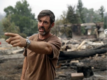 Matt Smith talks about how he fought an advancing wildfire and saved his home, while his neighbor's home, in the background, burned down Saturday, July 28, 2018, in Redding, Calif.