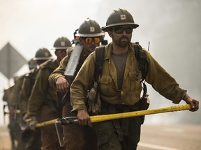 The El Dorado Hotshots battle wildfire near Buckhorn Summit on Highway 299 in Trinity County, Calif., Monday, July 30, 2018. A pair of wildfires that prompted evacuation orders for nearly 20,000 people barreled Monday toward small lake towns in Northern California, and authorities faced questions about how quickly they warned residents about the largest and deadliest blaze burning in the state.