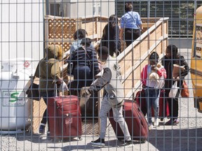 A group of asylum seekers arrive at the temporary housing facilities at the border crossing Wednesday May 9, 2018 in St. Bernard-de-Lacolle, Quebec.