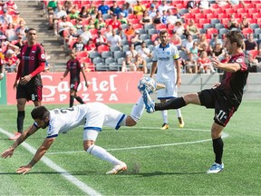 As Marco Franco, left, of Penn FC falls to the turf, Daniel Haber (11) of Fury FC plays the ball during Saturday's United Soccer League match at TD Place stadium. Haber, who joined Fury FC this past week, entered the game as a second-half substitute. Steve Kingsman/Freestyle Photography for Ottawa Fury FC