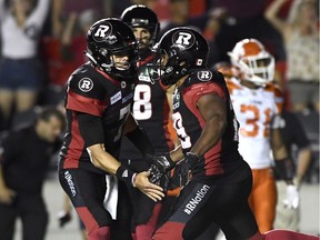 Ottawa Redblacks quarterback Trevor Harris (7) high fives teammate William Powell (29) after his 25-yard catch-and-run during second half CFL action against the B.C. Lions, in Ottawa on Friday, July 20, 2018.