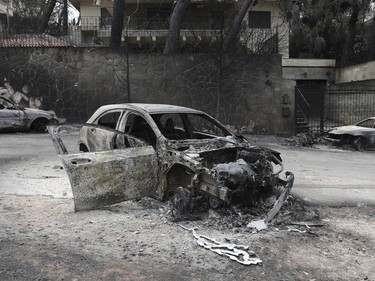 Melted metal from a burned-out car that was destroyed in the wildfires near the village of Neos Voutzas near Athens, Tuesday, July 24, 2018. Greece sought international help through the European Union as fires on either side of Athens left lines of cars torched, charred farms and forests, and sent hundreds of people racing to beaches to be evacuated by navy vessels, yachts and fishing boats.(AP Photo/Yorgos Karahalis) ORG XMIT: TH137