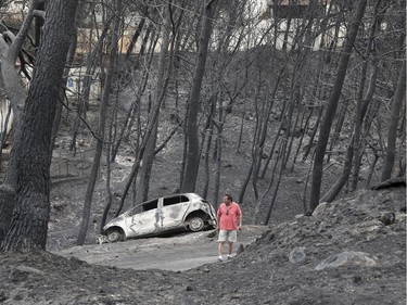 A man stands amongst the charred trees and a burned-out car near the village of Neos Voutzas near Athens, Tuesday, July 24, 2018. Greece sought international help through the European Union as fires on either side of Athens left lines of cars torched, charred farms and forests, and sent hundreds of people racing to beaches to be evacuated by navy vessels, yachts and fishing boats.(AP Photo/Yorgos Karahalis) ORG XMIT: TH127