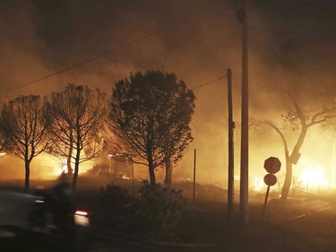 Buildings burn in the town of Mati, east of Athens, Monday, July 23, 2018. Regional authorities have declared a state of emergency in the eastern and western parts of the greater Athens area as fires fanned by gale-force winds raged through pine forests and seaside settlements on either side of the Greek capital.