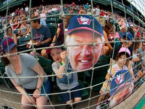 Fans hold up Hal Lanier flatheads to honour the former Winnipeg Goldeyes manager who had his number retired on Thursday.