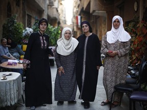 In this Monday, July 16, 2018 photo, Palestinian Abdul-Mahmoud sisters from right to left, Amal, Hanan, Izdihar, Myasar, pose for a picture outside their house on Lod street at the Palestinian refugee camp of Yarmouk in the Syrian capital Damascus, Syria. The four sisters spent Syria's seven-year conflict in the Yarmouk camp living through intense bombardment, food shortage and strict rule by members of the Islamic State group that controlled much of the camp for three years until May.