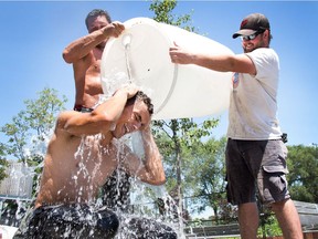 After working to take down some tents at Lansdowne Park, Abdallah Karoubi gets doused with water from fellow workers, Ben Oitzl (L) and Brendan MacMaster (R), from Parliament Parties, as they empty a barrel of water used as an anchor for the tents and manages to cool off as the region continued to experience a heat wave.